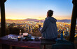 © Westend61 - Chile, Santiago, woman drinking a beer in the mountains above the city at sunset