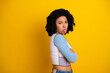 © deagreez - Playful young woman posing with cheerful expression and vibrant hairstyle against a bright yellow studio background
