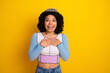 © deagreez - Happy young woman in casual trendy outfit with crown against yellow background expressing joy and surprise