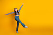 © deagreez - Joyful young woman dancing in denim jeans and a colorful crop top against a bright yellow backdrop for lifestyle fashion and music themes