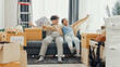 © tirachard - Young happy Asian sweet couple hold each other hand walking inside the new house sit on sofa couch in living room together. Husband wife move new home, Apartment Rent And Ownership Concept.