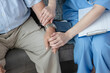 © Ratirat - Close-up nurse holding senior man's hand during home care visit, offering comfort and support. Compassionate healthcare, patient monitoring, recovery, medical consultation at home.