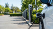 © Chdesignme - Close-up of a white vehicle during electric car charging in an urban environment