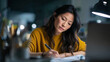 © Yaroslav Stepannikov - Young Asian woman concentrating on handwritten notes during work, desk with laptop in background, realistic lifestyle photography, premium advertising tone