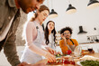 © Maria Vitkovska - Diverse friends preparing homemade pizza together in a modern kitchen