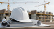 © Alina - White safety helmet on technical documents at construction site, safety and planning in architecture