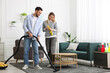 © New Africa - Couple tidying up living room together. Domestic chores