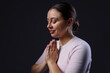 © New Africa - Woman praying on black background, space for text