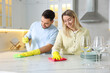 © New Africa - Couple cleaning white marble table together in kitchen