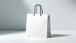 © Anastasiya - Minimal white shopping bag mockup with black rope handles, clean studio light, perfect for luxury branding and packaging.