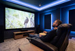 © Meow Creations - Man relaxing in luxury home theater watching nature documentary on large screen