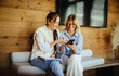 © Jacob Lund - Young colleagues reviewing ideas on smartphone in startup workspace