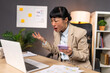 © Graphicroyalty - Frustrated Asian businesswoman shouting at laptop. Angry employee with smartphone, Workplace Stress concept. Stressed woman in beige blazer gesturing with hand while looking at computer screen.