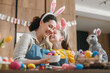 © Konstantin Yuganov - Mother and Daughter Celebrating Easter with Colorful Eggs and Bunny Ears