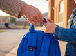© Aurora Aesthetics - Volunteer hand giving school backpack to child education charity donation support background copy space youth hope future learning student