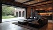 © Viktor - Modern garage living space transitions to patio and backyard. Black leather sofa, brick wall, wood ceiling. Open garage door connects indoor outdoor.