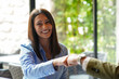 © Alaphotography - Smiling woman greets a man with a handshake inside a cafe during the day