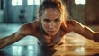 © COK House - A woman in a gym is intensely performing an exercise on the floor, demonstrating willpower and physical fitness, which is ideal as motivational background for fitness apps or training programmes.