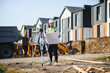 © Serhii - Surveyor checking blueprint at new residential construction site