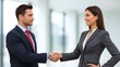 © SHAKAHWAT - Business professionals shaking hands in office setting