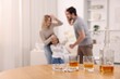 © New Africa - Alcohol addiction. Drunk man abusing his wife and daughter at home, focus on whiskey and cigarettes