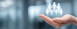 © Snowstudio - Hand holding family icons with a blurred office background