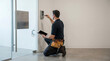 © Art_spiral - Commercial security technician installing smart door access keypad system using tablet for configuration and building entry control in modern facility