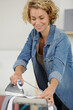 © auremar - young woman ironing clothes on ironing board