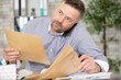 © auremar - busy businessman sorts through envelopes while talking on telephone
