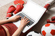 © Pixel-Shot - Female blogger using laptop and sports equipment on carpet, closeup