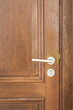 © Nattawit - A brown wooden door with polished alloy material doorknob handle of the domestic room, close-up and selective focus. Building interior equipment part object.