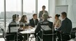 © Dave Dean - Confident businesswoman leading meeting in modern office with team