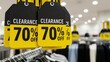 © MT - Yellow clearance sale tags with 70 percent discount hanging in a retail clothing store