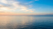 © Echt&KIreativ - Vast tranquil ocean surface reflecting a soft gradient sky with wispy cirrus clouds at dawn, creating a serene natural background or presentation template.