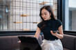 © Tj - Asian young woman working with digital tablet and phone