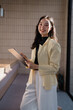 © Tj - Professional woman smiling holding clipboard working indoors