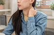 © Pormezz - female office worker rubbing her neck feel pain at her back and shoulder.