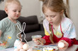 © Victoria - Easter. Children paint eggs. A boy and a girl.