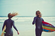 © peopleimages.com - Couple, running and surfing for fitness in ocean for travel, adventure and practice hobby. Back, people and space with surfer gear for extreme sports, outdoor activity and sea water for vacation trip
