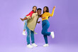 © Prostock-studio - A man gives a piggyback ride to a smiling girl while a woman strikes a joyful pose next to them in front of a purple backdrop. They all display happiness and energy.