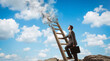 © ZaStock - Businessman looking up while climbing wooden ladder with smoke rising into clouds. Outdoor scene with bright blue sky and white clouds. Concept of career development, motivation, personal growth