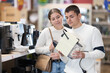 © JackF - Couple customer inspect product range and selects coffee machine. Client in hardware store picks up household appliances. Store of household appliances and household goods, showroom.
