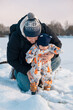 © phpetrunina14 - Father and Baby Enjoying Snowy Day Together.