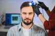© Serhii - Man receiving professional scalp analysis trichoscopy treatment