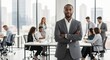 © WisChi - Confident Black businessman with arms crossed in modern office with diverse colleagues working in background