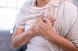 © Wasana - Woman experiencing chest pain holding chest feeling discomfort