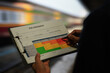 © Piya W. - Detailed shot of careful inspector holding clipboard with risk assessment document safety check busy railway station with serious focused mood