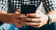 © Btc - Close-up of a man's hands holding a smartphone, browsing the internet or social media