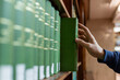 © Smallroombigdream - Hand selecting book from wooden library shelf. Legal research concept, attorney reference material, system study, academic knowledge and professional legislation archive.