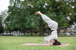 © leungchopan - Woman practice yoga headstand at park